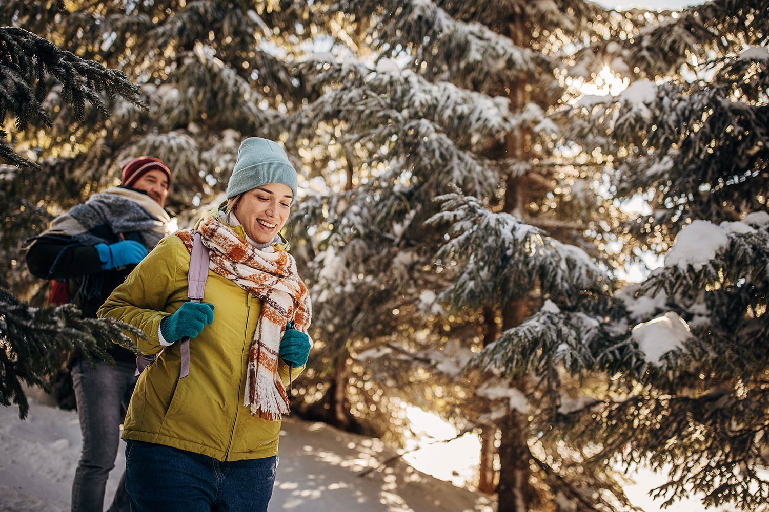 Un couple marche dans une forêt enneigée